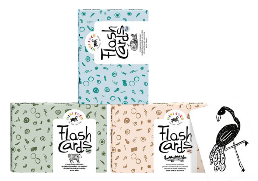 Drie kleurrijke bedrukte envelopdoosjes gebruikt als duurzame verpakking voor flashcards van Mini Coco, voorzien van vrolijke patronen in blauw, groen en beige met een witte illustratie van een flamingo; een perfect voorbeeld van kartonnen kaartverpakkingen op maat door Bedrukte-doosjes.nl.