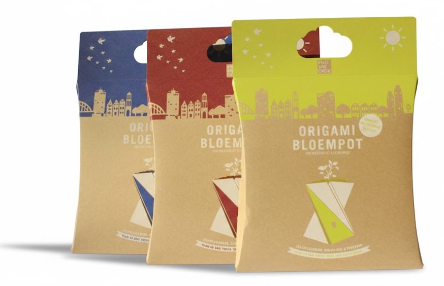 Drie milieuvriendelijke gondeldoosjes met handvat van bruin kraft karton met de afmetingen 270x250x30 mm, ontworpen als duurzame geschenkverpakking voor een 'Origami Bloempot'. De kussendoosjes (pillow boxes) zijn bedrukt met een skyline-illustratie en hebben kleurrijke bovenzijdes in blauw, rood en groen met een uitgestanst handvat voor een luxe tasdoos-uitstraling. Deze milieuvriendelijke verpakkingen van biologisch afbreekbaar Kraftpak karton laten zien hoe een bedrukt gondeldoosje met logo een natuurlijke en professionele uitstraling combineert, ideaal voor retailproducten, weggevers of als opvallende productverpakking in een winkelrek.