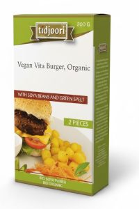 Een verticaal ontworpen, bedrukte doos voor biologische diepvriesproducten van het merk Tidjoori, specifiek voor de 'Vegan Vita Burger, Organic'. De verpakking is vervaardigd uit stevig, koeling-geschikt wit karton met een licht glanzende afwerking en een gewicht van 200 gram voor twee burgers. Op de voorzijde staat een smakelijke serveersuggestie van een burger op een broodje met kaas, tomaat en gebakken aardappeltjes, wat de klant overtuigt van de kwaliteit van deze vleesvervanger met sojabonen en groene spelt. Door het merklogo en de groene kleuraccenten op de doos te laten drukken, wordt de merkidentiteit en naamsbekendheid in het schap van de diepvries versterkt. Deze professionele verpakking beschermt de inhoud optimaal, verlengt de houdbaarheid en biedt ruimte voor belangrijke informatie zoals de biologische certificering en ingrediënten.