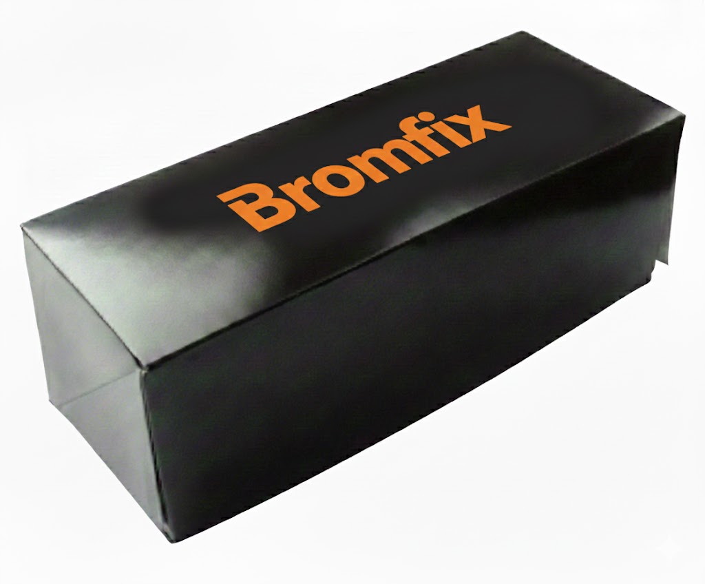 Een nauwkeurige, hoog-hoek close-up van een rechthoekige, zwarte bedrukte gebaksdoos of schnittedoos met een glanzende afwerking, geïsoleerd op een witte achtergrond. De doos is langwerpig en compact, perfect voor het verpakken van een gebakje of schnitte. Centraal op de bovenkant van het deksel staat het woord 'Bromfix' gedrukt in een opvallende, helder oranje kleur. De doos is gesloten, met zichtbare vouwnaden aan de zijkant, wat de vouwkartonkwaliteit en stevigheid benadrukt. Dit beeld illustreert een stijlvolle en professionele merkbeleving via verpakkingen met logo, en sluit direct aan bij de beschrijving van gepersonaliseerde gebaksdozen als visitekaartje en relatiegeschenk. De minimalistische, donkere kleur en het felgekleurde logo creëren een luxe, herkenbare uitstraling, geschikt voor het verpakken van lekkernijen zoals een Bossche bol, cupcake, kerststol of taart.