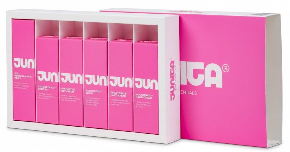 Een luxe, op maat gemaakte schuifdoos met interieur en bijbehorende bedrukte cosmetica doosjes van Junita Skincare, uitgevoerd in een zeer opvallende fluor roze kleur. De set bevat de 'Dermal Discovery kit' met zes kleine cosmeticadoosjes die perfect passen in de grotere schuifdoos van 235 x 143 x 38 mm. Het ontwerp is minimalistisch met een herkenbaar wit logo en strakke typografie, wat een krachtig contrast vormt met de neonroze achtergrond. Deze professionele verpakking voor de probleemhuid ('designed for difficult skin') illustreert hoe gedurfde, opvallende kleuren en een kwalitatief hoogwaardig ontwerp uw merk direct laten onderscheiden van de rest.