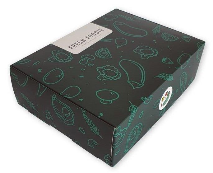 Een luxe, zwart bedrukte doos voor diepvriesmaaltijden van het merk Fresh Foodie, uitgevoerd met een stijlvol groen patroon van diverse groenten zoals aubergines, broccoli en champignons. Deze op maat gemaakte maaltijdverpakking van koeling-geschikt karton heeft een professionele uitstraling die de merkidentiteit versterkt en de klant overtuigt in het schap. De stevige doos beschermt de inhoud optimaal tijdens opslag in de diepvries of koeling, waardoor de kwaliteit van de maaltijd behouden blijft. Het ontwerp bevat een duidelijk wit tekstvak met het logo 'Fresh Foodie', wat bijdraagt aan de naamsbekendheid en herkenbaarheid voor herhaalaankopen. Dit type doos is ideaal voor het verpakken van gezonde diepvriesproducten en biedt voldoende ruimte voor het vermelden van een gebruiksaanwijzing of allergie-informatie.