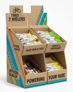 Voorbeeld van een op maat gemaakte, dubbele kartonnen baliedisplay voor Tinus2wielers met een gepersonaliseerde full-color opdruk voor een fietsenmaker. Deze toonbankdisplay is voorzien van teksten zoals "Official Dealer" en "Alles voor je fiets", en toont hoe mueslirepen, technische producten of accessoires gepresenteerd kunnen worden. Geproduceerd door Drukkerij Van der Louw in Berkel en Rodenrijs, leverbaar vanaf 5 stuks voor de retailsector.