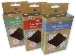 Drie voorbeelden van bedrukte hangende doosjes van bruin kraft karton met een eurolock ophangoog en een uniek gestanst venster. Deze retailverpakkingen voor Palo Santo Pop laten zien hoe kleurrijke bedrukking en natuurlijke materialen zorgen voor een professionele presentatie in winkelrekken.