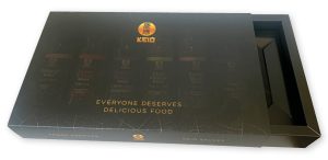 Matgelamineerd full-color schuifdoosje met een op maat gemaakt interieur voor sausflesjes van Yama-G. Deze luxe zwarte lade-doos verpakking met gouden bedrukking fungeert als presentatiedoos en geschenkverpakking, vakkundig geproduceerd door Drukkerij Van der Louw in Berkel en Rodenrijs.