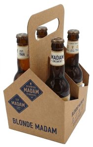 Luxe, gepersonaliseerde 4-pack bierverpakking van stevig vouwkarton met een robuuste natural brown 'kraft' look. De doos is uitgevoerd als een gesloten houder voor vier 33cl flesjes, met een geïntegreerde handgreep aan de bovenzijde voor veilig draaggemak. Op de voorzijde staat een donkerblauw, ruitvormig badge met de tekst 'Brouwerij MADAM Brouwerij' in witte letters. De zijkant toont de tekst 'BLONDE MADAM' in donkerblauwe, gestileerde letters, met de toevoeging 'Est. MADAM BEITONEN WARE' eronder. Het dichte model omsluit de flesjes volledig, waardoor alleen de kroonkurken en de bovenste halzen van de vier Madam Brewery flesjes met het 'EST. 1966' text zichtbaar zijn. Een perfect voorbeeld van een gepersonaliseerde 33cl 4-pack flesverpakking met hoogwaardige bedrukking direct op het karton.
