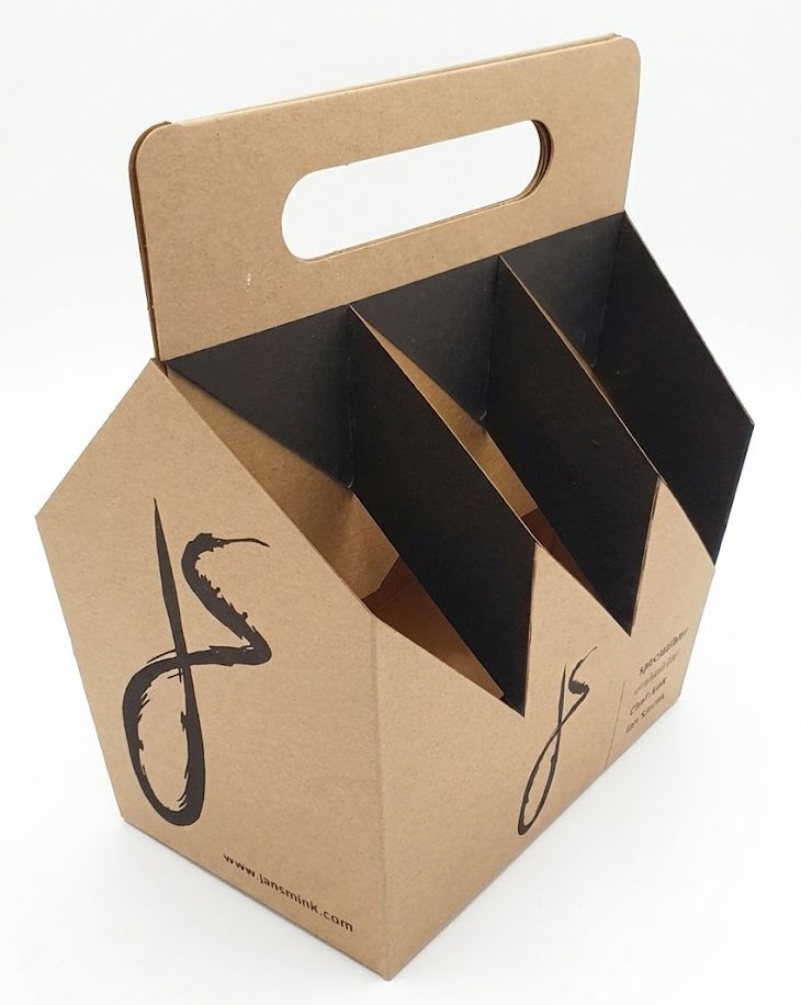 Een op maat bedrukte kartonnen bierdraagverpakking voor 6 flessen speciaalbier, uitgevoerd in natuurlijk bruin kraftkarton met zwarte accenten. De verpakking is voorzien van een handige draaggreep en toont het logo van Jan Smink in een gestileerd zwarte penseelstreek op de voor- en zijkant. Onderaan de voorzijde staat de website www.jansmink.com. Op de zijkant staat de tekst: 'speciaalbier ontwikkeld door Chef-kok Jan Smink'. De binnenzijde van de vakken is afgewerkt met zwart karton voor een luxe uitstraling. Ideaal als exclusieve geschenkverpakking voor lokale ambachtelijke bieren uit Berkel en Rodenrijs.