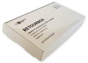 Een witte, rechthoekige kartonnen retourbox voor medische zendingen, schuin van boven gefotografeerd op een witte achtergrond. De doos is bedrukt met zwarte inkt en bevat in een vet, schreefloos lettertype de tekst 'RETOURBOX'. Daaronder staan de adresgegevens van Medische Laboratoria Dr. Stein & Collegae in Valkenburg. Aan de linkerzijde is het logo van Medische Post' met een enveloppe-icoon zichtbaar en rechtsboven een barcode met de tekst 'Geen postzegel nodig'. Deze professionele verzendverpakking is op maat gemaakt door Drukkerij Van der Louw.