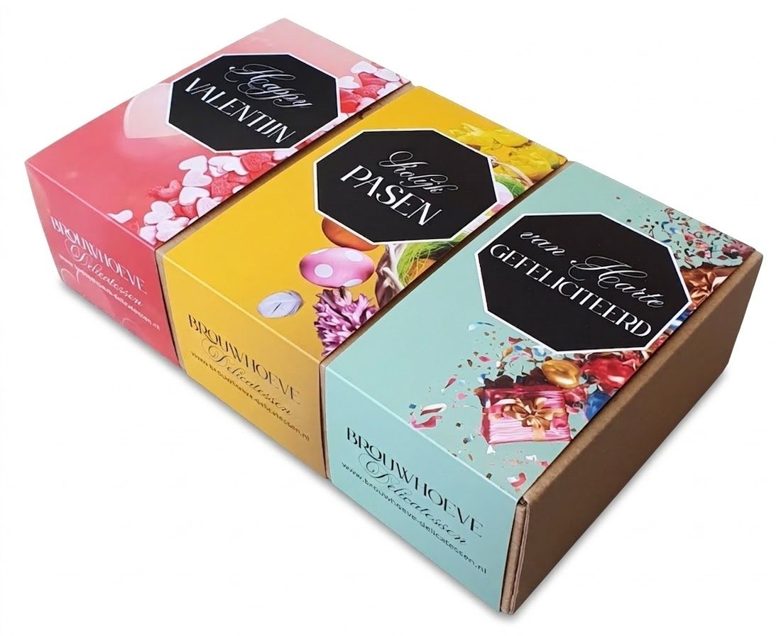 Drie voorbeelden van op maat gemaakte kartonnen sleeves voor Brouwhoeve Delicatessen, geschoven om blanco bruine verzenddoosjes. De wikkels zijn full-color bedrukt in de thema's 'Happy Valentijn' (roze met hartjes), 'Vrolijk Pasen' (geel met paaseieren) en 'Van Harte Gefeliciteerd' (mintgroen met confetti). Deze gepersonaliseerde verpakkingswikkels tonen hoe een standaard doosje eenvoudig een luxe, seizoensgebonden uitstraling krijgt door middel van een bedrukte sleeve. Geproduceerd in eigen huis door Drukkerij Van der Louw.