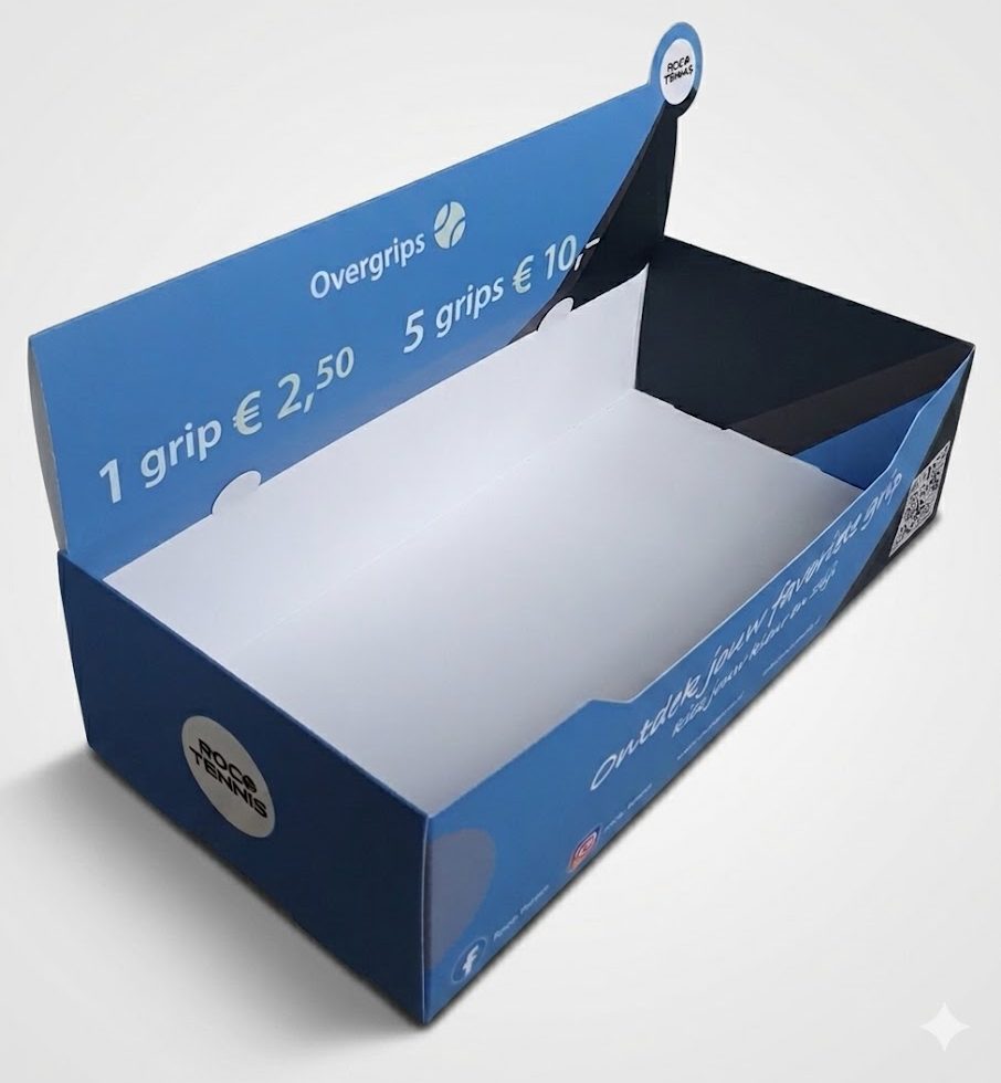 Een blauwe bedrukte displaydoos van karton voor Rocco Tennis overgrips, vrijstaand gefotografeerd met een zachte slagschaduw. De toonbankdisplay toont prijzen voor tennisgrips en is geproduceerd door Drukkerij Van der Louw, specialist in op maat gemaakte displaydozen sinds 1966.