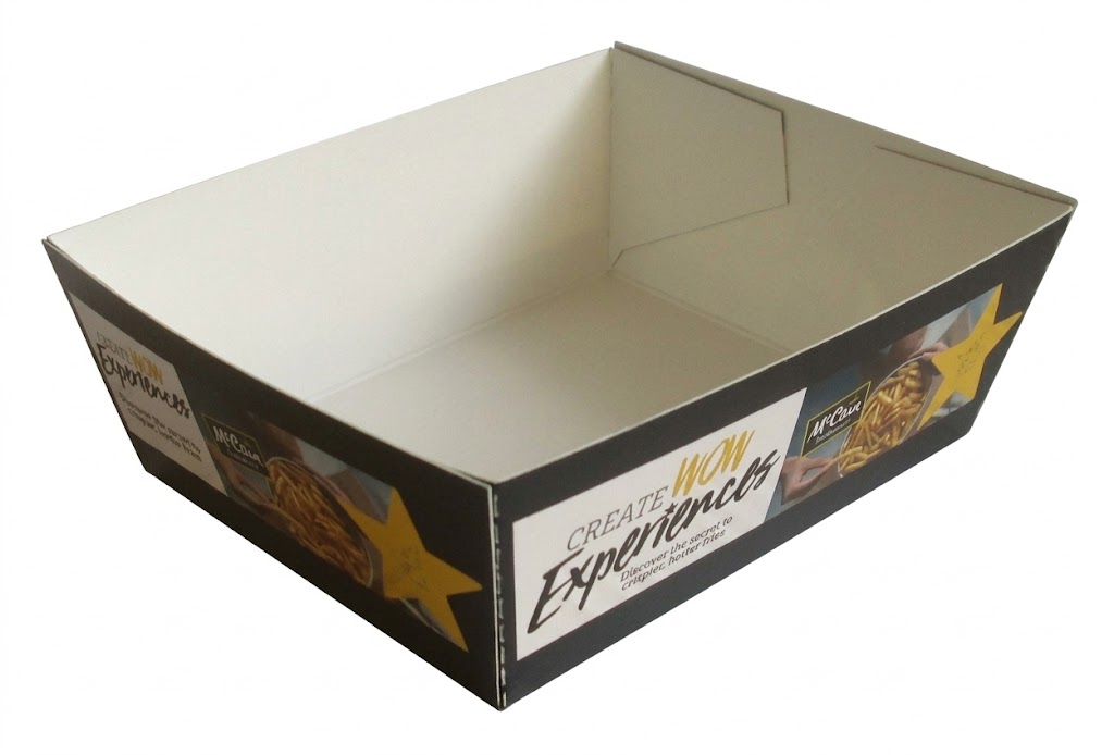 bedrukt kartonnen patatbakje van McCain Foodservice als op maat gemaakte snackverpakking. De afbeelding toont een schuin vooraanzicht van een fysieke, open kartonnen tray met een zwarte buitenkant en een witte binnenkant, vrijstaand gepresenteerd. Op de zijkant is een opvallend wit tekstvlak te zien met de tekst 'CREATE WOW Experiences' en de kleine subtekst 'Discover the secret to crispier, hotter fries'. Rechts daarvan staat het logo van 'McCain Foodservice' naast een afbeelding van goudgele frietjes en een grote gele ster. Deze tastbare, op maat geproduceerde horeca-verpakking is ontworpen voor professionele presentatie van frituursnacks